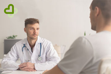 Мужчина сидит на приеме у врача